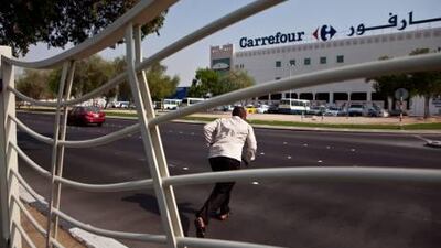 A man runs across Airport Road towards Carrefour near where three little girls died two years ago. The tragedy has led to rigorous safety campaigns, the development of crossings and a drop in pedestrian fatalities.