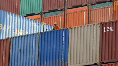 A worker sits on a ship carrying containers at Mundra Port. Amit Dave / Reuters