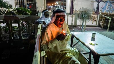 Saeed relaxes outside in the cool evening with his midwakh, or Arabian pipe, in which he smokes dokha, a sifted tobacco product mixed with aromatic leaf and bark herbs.