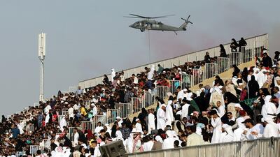 Crowds watch as a helicopter swoops in for a live action hostage rescue mission