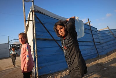 A girl carries water in a camp for displaced Palestinians in Khan Younis. AFP