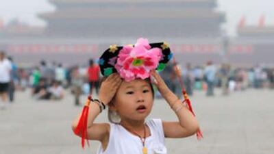 A little girl tries on a princess head dress in Tiananmen Square in Beijing.