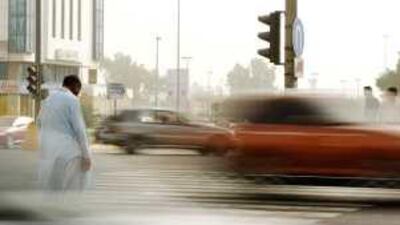 A man waits on Airport Road in Abu Dhabi to cross. A study has shown the UAE has among the highest road death rates in the world.