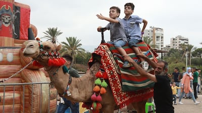 Syrian children ride a camel as they play in a park in the Lebanese capital Beirut during Eid Al Adha. AFP