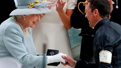 Frankie Dettori shakes hands with Queen Elizabeth II (L) during the presentation after he won the Gold Cup on Day 3 at Royal Ascot. AFP
