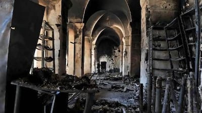 A Syrian rebel (rear) inspects a burnt section of the Umayyad Mosque in the old city of Aleppo, hours before the Syrian army retook control of the complex.