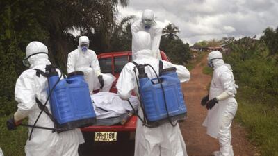 Health workers load the body of a dead woman suspected of dying from Ebola, onto the back of a truck in Jene-Wonde, Liberia. A schoolteacher brought his sick daughter from Liberia’s capital to this small town of 300 people. Soon he was dead along with his entire family, all buried in the forest nearby. Wade Williams / AP Photo