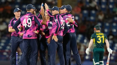 Scotland players celebrate the dismissal of Australia batsman David Warner. AP