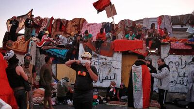 Protesters stage a sit-in on barriers at the Sinak Bridge, leading to the Green Zone government areas. AP