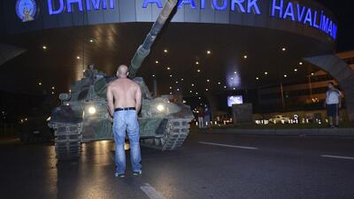 A man stands in front of a tank at the entrance to Istanbul's Ataturk airport in the early hours of Saturday. Turks resisted the army using only their bodies. (Ismail Coskun/IHA via AP)