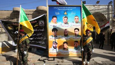 Members of the Kataeb Hezbollah, part of Iraq's government-affiliated Popular Mobilisation Forces, stand in front of portraits of fellow members killed in air raids across the border in Syria on June 17, 2018, during a memorial ceremony in Baghdad on June 21, 2018. Ahmad Al Rubaye / AFP