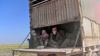 Alleged ISIS fighters and their families sit in the back of a truck as they leave the group's last holdout of Baghouz in Syria. AFP