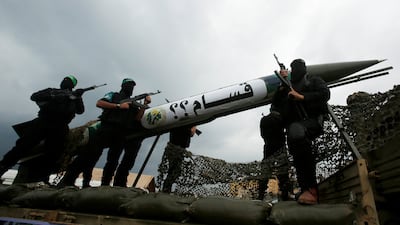 Hamas fighters with a rocket during a military parade in Gaza. The group is to disarm under a deal hailed by the Board of Peace. Reuters