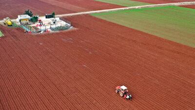 This aerial view shows Syrian potato farmers using a tractor to plant the root vegetables near the town of Binnish in Syria's northwestern Idlib province. AFP
