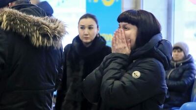 Relatives and friends of those on the Saratov Airlines airline plane An-148 flight that crashed near Moscow's airport Domodedovo react while gathering at an airport outside Orsk, Russia. Orsk.ru via AP