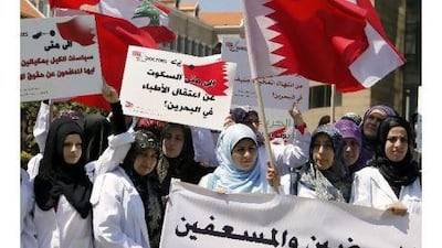 Lebanese doctors, supporters of Hezbollah, carry placards, one reading in Arabic 'Why keeping silence about arrests of doctors in Bahrain' and wave Lebanese and Bahrain flags during a demonstration in solidarity with the doctors and nurses arrested in Bahrain in Beirut yesterday.
