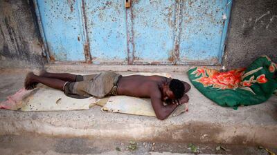 A man from the Akhdam community sleeps on the side of a street.