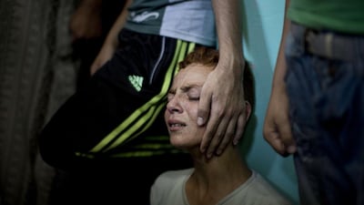 A relatives of senior Hamas commander Raed al-Atar, one of three senior Hamas commanders killed in an Israeli military strike, mourns during his funeral in the southern Gaza Strip town of Rafah. Israeli warplanes killed three top Hamas commanders in southern Gaza inflicting a heavy blow on the movement’s armed wing after failing to kill its top military chief. Mahmud Hams / AFP