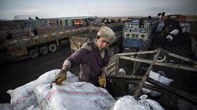 Afghan youth, Aman shifts a sack of coal to be transported to Pakistan.
