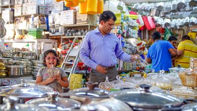 A father and daughter shop for kitchenware at the home furnishings area of Al Mina Souq