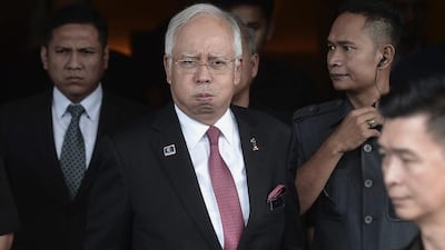 Najib Razak, the Malaysian prime minister centre, reacts as he leaving after attending a parliament session in Kuala Lumpur. he was cleared for any wrong-doing in a $700m donation scandal. EPA