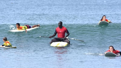 Senegalese surfer Oumar Seye (C) teaches surf students at Almadie beach in Dakar. AFP Photo Seyllou