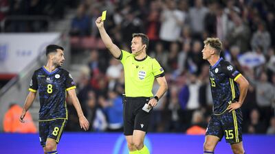 Besar Halimi of Kosovo is shown a yellow card by referee Felix Zwayer.