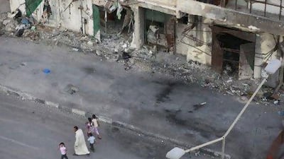 A family walks past the ruins of Tripoli Street in Misurata, where the firefights have left many children emotionally and psychologically scarred.