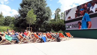Spectators watch Stefanos Tsitsipas on a big screen during the 2019 French Open. EPA