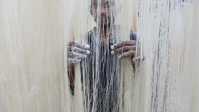 A worker dries Seviiyan (thin vermicelli) which is used for the preparation of 'sheerkhorma', a traditional sweet dish prepared by the Muslim community during the holy month of Ramadan, at a food factory in Hyderabad. Noah Seelam / AFP
