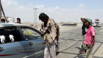Members of the pro-government Popular Committees militia inspect a car at a checkpoint on a road leading to Yemen's southern province of Abyan December 2, 2015. Al Qaeda fighters retook on Wednesday two southern Yemeni towns they briefly occupied four years ago, residents and local fighters said, exploiting a collapse of central authority in Yemen which is in the throes of an eight-month war. REUTERS/Nasser Awad