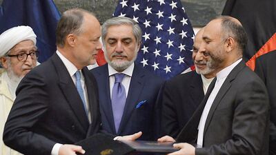 Afghan national security adviser Hanif Atmar, right, and US ambassador to Afghanistan James Cunningham, second left, signed a security agreement allowing about 10,000 US troops to stay in Afghanistan next year. Shah Marai/AFP Photo