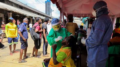 Sri Lankan health workers carry out Covid-19 swab tests at a public market in Colombo, Sri Lanka. EPA