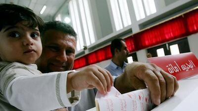 A Bahraini man and his son cast a ballot during the 2006 November elections