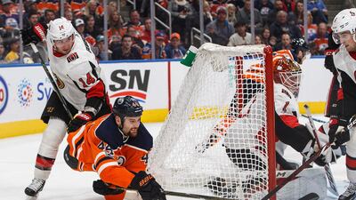 Ottawa Senators' Alex Burrows hooks Edmonton Oilers' Zack Kassian as he tries to put the puck past goalie Mike Condon during the second period of an NHL hockey game in Edmonton, Alberta. Jason Franson / The Canadian Press via AP