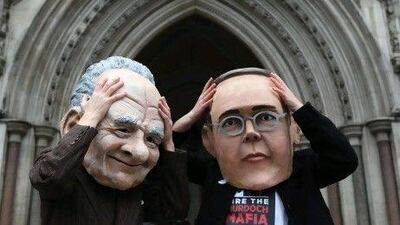 Protesters from a campaign group demonstrate outside the High Court where the Levenson Inquiry is taking place wearing oversized masks of James, right, and Rupert Murdoch.