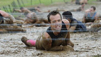 A participant crawls under a barbed wire barrier during a Spartan Race in Australia two years ago. Mick Tsikas / EPA