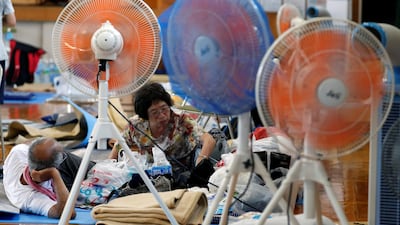 Local residents take rest near electrical fans at Okada elementary school in Kurashiki, Okayama. Reuters