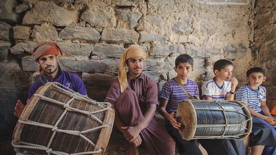 Boys play their grandfathers’ drums outside the courtyard where shuwah cooks underground. Ania James for The National