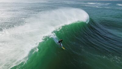 A surfer rides a wave at the Cape Peninsula in Cape Town, South Africa. Reuters