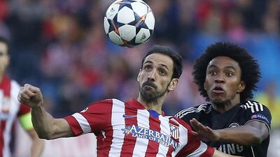 Atletico's Juanfran, left, clears the ball from Chelsea's Willian during their Uefa Champions League semifinal first leg soccer match between Atletico Madrid and Chelsea at the Vicente Calderon stadium in Madrid, Spain, Tuesday, April 22, 2014. AP Photo/Andres Kudacki