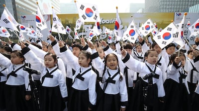 Schoolgirls wave the Korean flag.