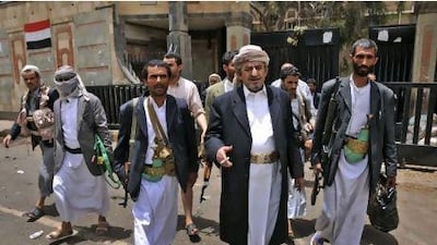 Sheik Sadeq al Ahmar, centre, the head of the powerful Hashed tribe, walks with his bodyguards near his home in Sana'a yesterday. Mohammed al Sayaghi / AP Photo