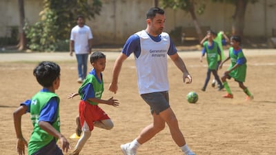 Former Barcelona and Spain midfielder Xavi is welcomed during the ground breaking ceremony of an astro-turf football pitch in Mumbai.