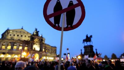 A sign featuring veiled women is held by a Pegida supporter at a rally in Dresden, Saxony, eastern Germany, in October 2015. AFP