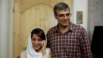 Iranian lawyer Nasrin Sotoudeh speaks on the phone next to her husband Reza Khandan as they pose for a photo at their house in Tehran. AFP