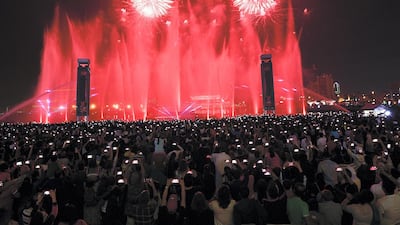 People enjoy the fireworks at Dubai Festival City in Dubai on Monday. Satish Kumar/ for The National