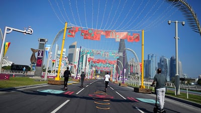 People drive electric scooters on a street along the beach promenade in Doha. AP