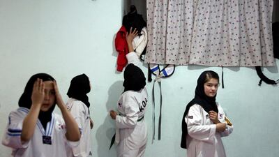 Taekwondo club members athletes get dressed ahead of their practice in Kabul, Afghanistan, Saturday, Feb. 23, 2020. AP