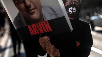A placard bearing the face of a victim of Flight PS752 is carried in Toronto. The Canadian Press via AP
